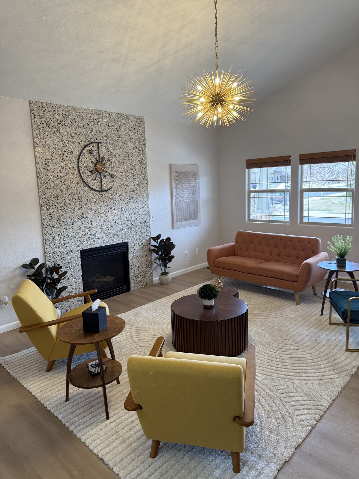 Mid-century modern great room remodel with vaulted ceiling, terrazzo fireplace, and sputnik chandelier by Far West Construction in Fort Collins, CO