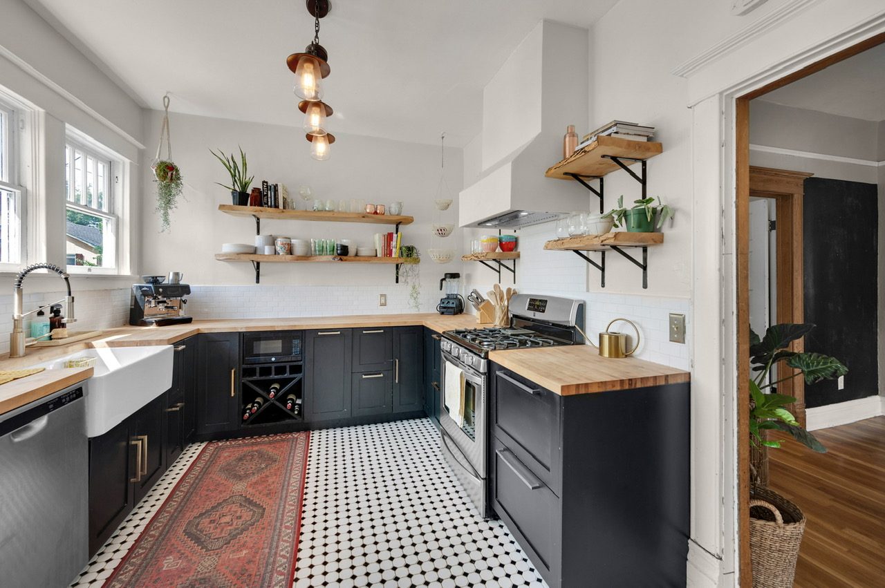 Historic home kitchen remodel with dark cabinets, butcher block counters, and open shelving by Far West Construction in Fort Collins, CO