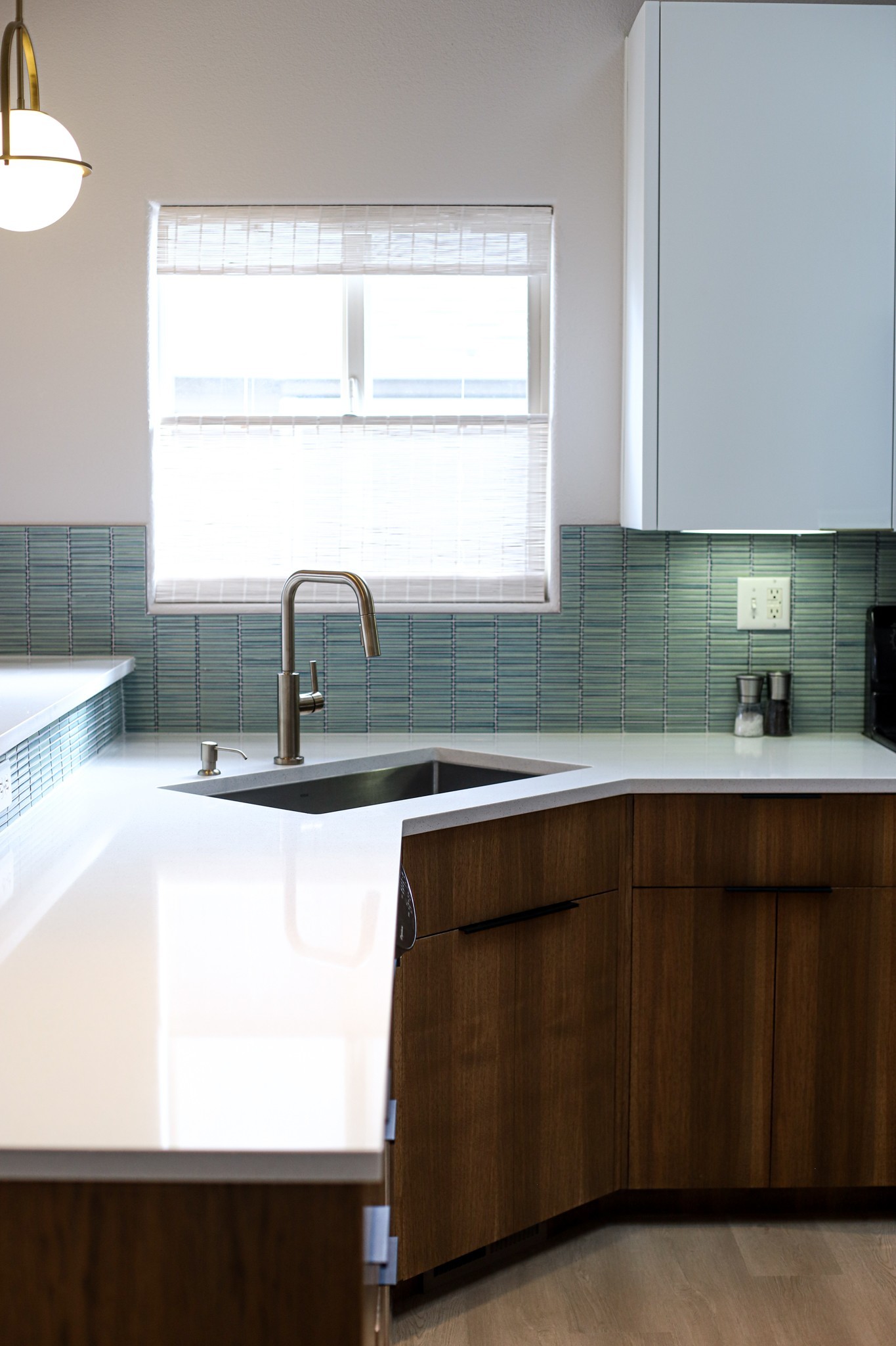 Mid-century modern kitchen remodel with teal glass tile backsplash and walnut cabinets by Far West Construction in Fort Collins, CO